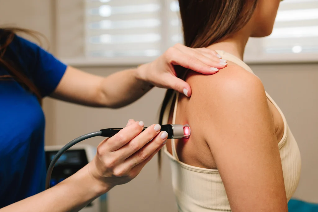 a woman getting laser therapy to help with her shoulder pain